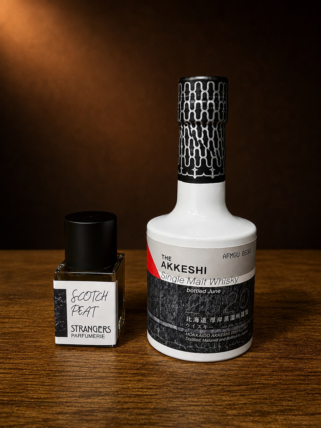 Akkeshi Sarorunkamuy whisky bottle beside Strangers Parfumerie Scotch Peat perfume bottle