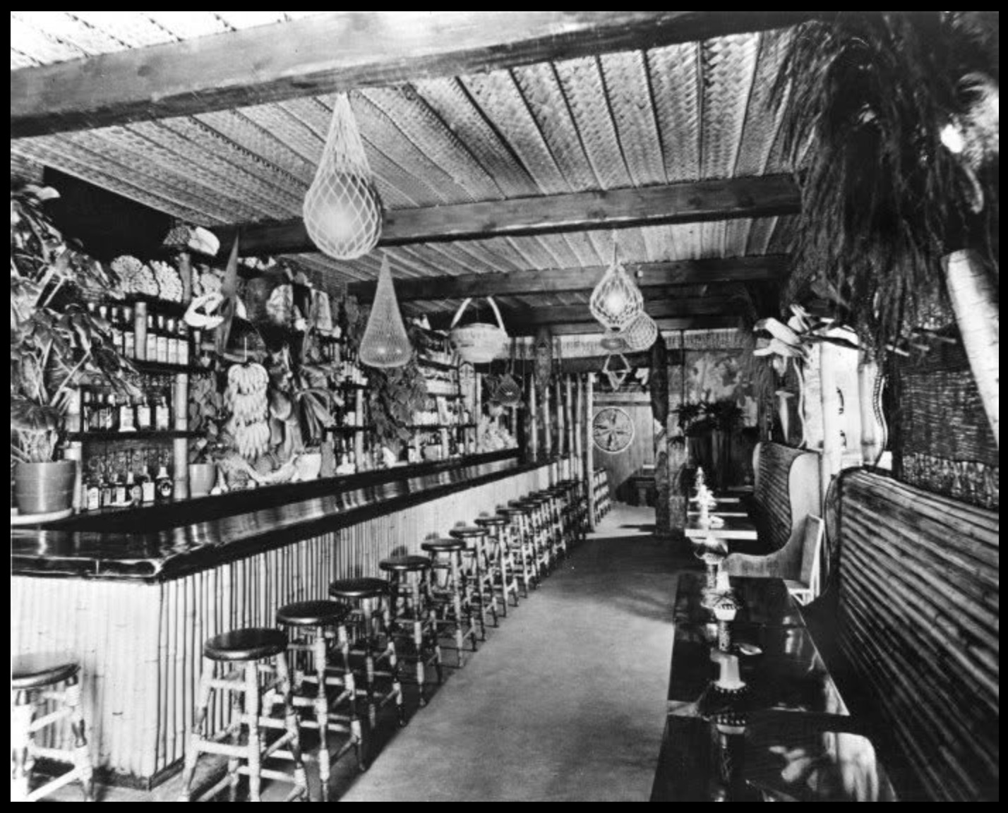 Interior of an early Don the Beachcomber tiki bar, bamboo stools and hanging floats