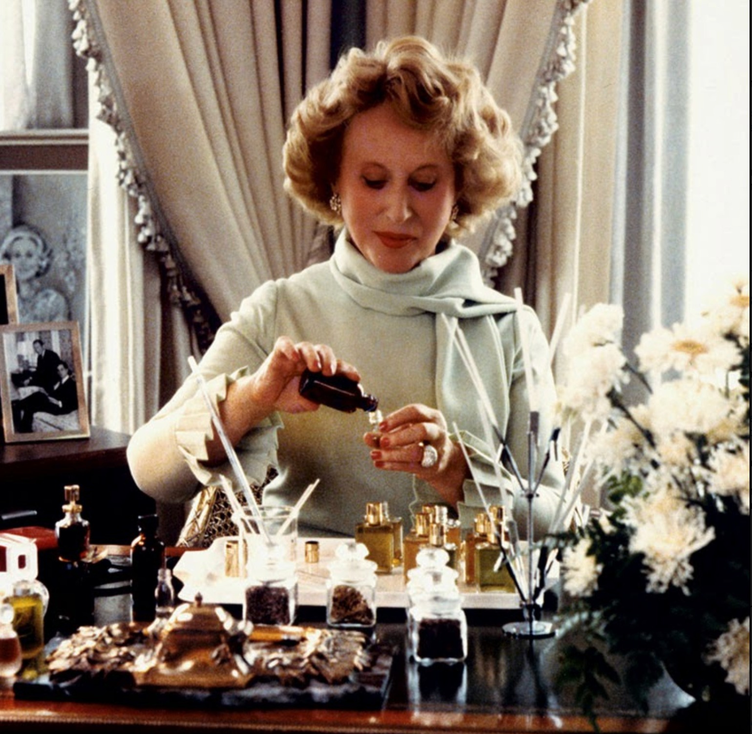 Estee Lauder mixing fragrance oils at her desk